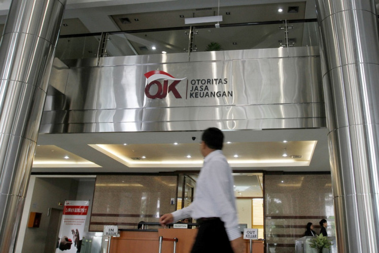 Someone’s watching: A man walks past the Financial Services Authority (OJK) building in Central Jakarta on May 15, 2013.