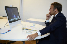 French President Emmanuel Macron (right) listens to US President Donald Trump (on the screen) during a donor tele-conference concerning the situation in Lebanon with other world leaders, from Fort de BreganÁon in southern France on August 9, 2020, after a huge blast rocked the Lebanese capital of Beirut killing in excess of 150 people. 