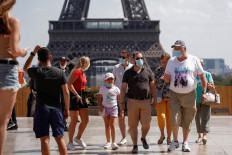People wearing protective face masks walk at the Trocadero square near the Eiffel Tower in Paris as France reinforces mask-wearing as part of efforts to curb a resurgence of the coronavirus disease (COVID-19) across the country, August 9, 2020. 