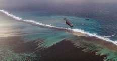 This aerial view taken on August 9, 2020 shows the site of containment operations for the leaked oil coming from the vessel MV Wakashio, belonging to a Japanese company but Panamanian-flagged, that ran aground near Blue Bay Marine Park off the coast of south-east Mauritius. - France on August 8, 2020 dispatched aircraft and technical advisers from Reunion to Mauritius after the prime minister appealed for urgent assistance to contain a worsening oil spill polluting the island nation's famed reefs, lagoons and oceans. Rough seas have hampered efforts to stop fuel leaking from the bulk carrier MV Wakashio, which ran aground two weeks ago, and is staining pristine waters in an ecologically protected marine area off the south-east coast.