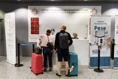 Passengers ask for instructions at the COVID-19 health information point of the Helsinki-Vantaa airport in Vantaa, Finland on August 3, 2020. Finland has removed most EU countries from its "green travel list", with only arrivals from a handful of states now able to enter the country without restrictions, the government announced on Wednesday.