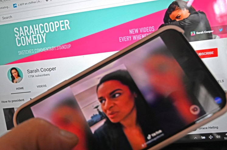 In this file photo illustration taken in Washington, DC, on July 16, 2020, shows YouTube's Sarah Cooper Comedy channel on a computer screen and a sketch of US author and comedian Sarah Cooper on a mobile phone. Cooper, the US comedian whose uncanny lip-sync.