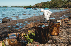 A volunteer cleans oil spilled from the bulk carrier ship MV Wakashio, belonging to a Japanese company but Panamanian-flagged, that ran aground on a reef, at the Mahebourg Waterfront in Riviere des Creoles, Mauritius, August 12, 2020. 