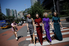 Members of an internet celebrity model group 'Glamma Beijing' (left to right), Lin Wei, 65, Sun Yang, 64, Wang Nianwen, 74, and Wang Xinghuo, 70, wearing traditional Chinese dresses walk across a street during a video shooting, following the coronavirus disease (COVID-19) outbreak, in Beijing's Central Business District (CBD) area, China, on August 13, 2020. 