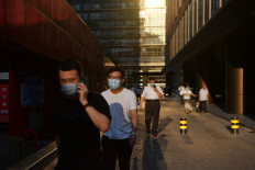 Masks on the street but not at work? Experts urge consistency