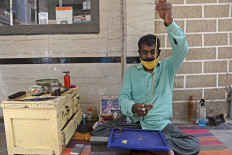 In this photograph taken in July 31, 2020, a goldsmith makes gold jewelry at a workshop in Hyderabad. 
