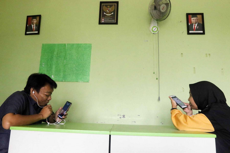 Biology teacher Wahyu Adi Prasetyo (left) and his colleague, English Rantiyani, an English teacher, teach online classes in South Tangerang, Banten, on Aug. 10. Without large internet data packages, some teachers have been forced to reduce the duration of their online classes. 