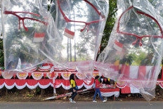 Two women pass by Independence Day-themed decorations in Depok, West Java, on Aug. 10. Although the pandemic still shows no signs of slowing down, some communities are still eager to hold festive Independence Day celebrations. 