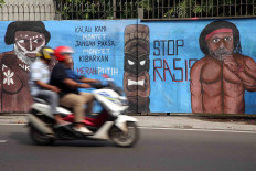 A mural shows two Papuans with the words: “If we are monkeys, don’t force monkeys to raise the white and red [Indonesian] flag. Stop racism.” The mural was displayed on a road connecting Depok and Bogor, West Java. The mural refers to an incident last year in Surabaya, East Java, in which a Papuan student was vilified and called a “monkey”. The incident led to a string of antiracism protests. 