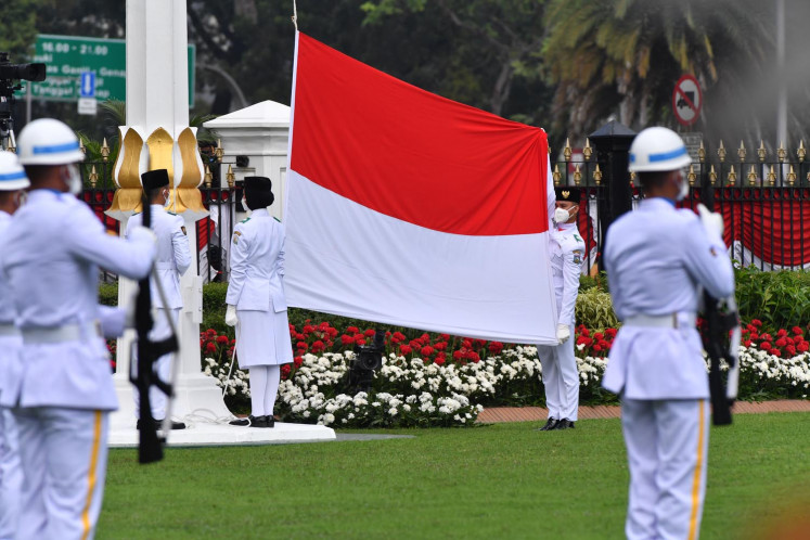 Three members of the national flag-hoisting team raise the Red-and-White on Aug. 17, 2020, during a ceremony to commemorate Indonesia's 75th anniversary at the Presidential Palace in Central Jakarta.
