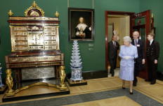 Queen Elizabeth II views a recently restored Rembrandt, 'Agatha Bas', and a Boulle secretaire -cabinet dated around 1700, 21 May 2002, on display in the Queen's Gallery at Buckingham Palace, London.