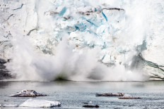 This file photo taken on August 17, 2019 shows an iceberg calving with a mass of ice breaking away from the Apusiajik glacier, near Kulusuk (aslo spelled Qulusuk), a settlement in the Sermersooq municipality located on the island of the same name on the southeastern shore of Greenland. / AFP