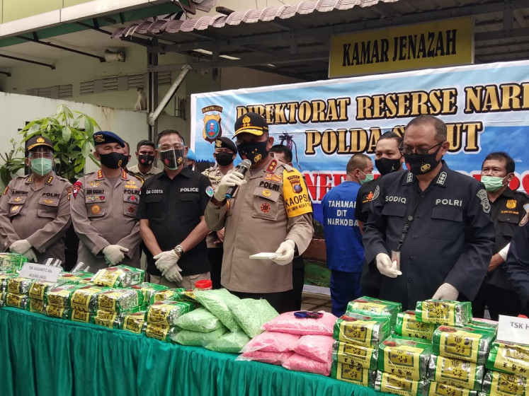 North Sumatra Police chief Insp. Gen. Martuani Sormin Siregar (center, holding the mic) presents evidence of 100 kilograms of crystal methamphetamine and 50,000 ecstasy pills seized from two suspects of an alleged Jakarta-Medan drugs syndicate, at Bhayangkara Hospital in the North Sumatra Brimob headquarters in Medan on Aug. 18, 2020. The suspects were apprehended in Jakarta on Aug. 15. However, one of them was shot dead in Medan after trying to assault an officer on Aug. 17.