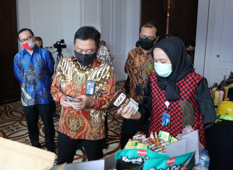 Supporting local producers: Telkom president director Ririek Adriansyah (second left) along with Telkom Strategic Portfolio director Budi Setyawan Wijaya (second right) and Telkom Digital Business director Muhamad Fajrin Rasyid (left) inspect a booth displaying products manufactured by local micro, small and medium enterprises (MSMEs) after the launch of the PaDi UMKM digital platform on Aug. 17 in Jakarta.