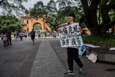 In this picture taken on on August 7, 2020 climate activist Howey Ou, 17, stages a protest on a street in Guilin. 
