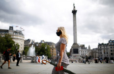 A person wearing a protective face mask walks through Trafalgar Square, amid the coronavirus disease (COVID-19) outbreak, in London, Britain, August 21, 2020. 