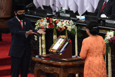 President Joko “Jokowi” Widodo presents the draft of the 2021 state budget to House of Representatives Speaker Puan Maharani during a plenary session on Aug. 14, 2020. 