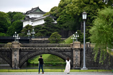 People take pictures of the Imperial Palace, a popular tourist destination, in Tokyo on May 20, 2020. 