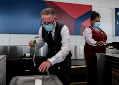 Delta Air Lines employees check in luggage at the Ronald Reagan National Airport on July 22, 2020 in Arlington, Virginia. 