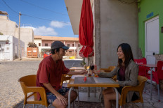 This handout picture taken on May 20, 2020 and provided by instagram@rikiya_trip on Aug. 24 shows Japanese couple Rikiya (L) and Ayumi Kataoka (R) at a local restaurant in the town of Santa Maria in Cape Verde. 