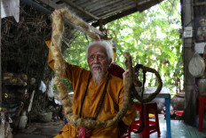 Nguyen Van Chien, 92, sits for a portrait to show his 5-meter long hair which, according to him, has not been cut for nearly 70 years, at his home in Tien Giang province, Vietnam, August 21, 2020. 