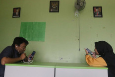 Biology teacher Wahyu Adi Prasetyo (left) and English teacher Rantiyani use mobile phones to deliver online learning on Aug. 10, 2020 in South Tangerang, Banten.