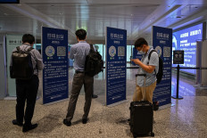 This photo taken on August 3, 2020 shows passengers checking their health codes on their phones upon arrival at Tianhe Airport in Wuhan in China’s central Hubei province. 