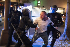 Portland police hold back Chandler Pappas who was with the victim of a fatal shooting as he reacts in minutes after the incident on August 29, 2020 in Portland, Oregon. Far left counter-protesters and pro-Trump supporters clashed Saturday afternoon as a parade of cars carrying right wing supporters made their way from nearby Clackamas to Portland.   