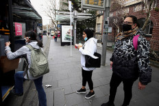People wearing face masks prepare to board a bus on the first day of New Zealand's new coronavirus disease (COVID-19) safety measure that mandates wearing of a mask on public transport, in Auckland, New Zealand, August 31, 2020.  