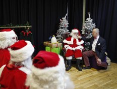This file photo taken on November 16, 2017 shows instructor James Lovell adjusting the costume of a student Santa during a training session at The Ministry of Fun Santa School in London. 