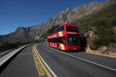 An almost empty tour bus drives below the city's iconic landmark Table Mountain in Cape Town, South Africa, during the coronavirus disease (COVID-19) outbreak, on August 22, 2020. 