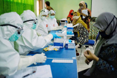 Health workers conduct COVID-19 rapid tests on teachers at SMP 3 state junior high school in South Tangerang, Banten, on Aug. 27. Authorities held rapid tests for middle school teachers in Ciputat, Tangerang, to trace the spread of COVID-19 and prevent further coronavirus outbreaks in the area. JP/Seto Wardhana