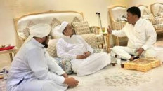 Islam Defenders Front (FPI) leader Rizieq Shihab (center) receives a visit from Indonesian Democratic Party of Struggle (PDI-P) politician Erwin Moeslimin Singajuru (right) on April 23, 2018 during his self-imposed exile in Mecca, Saudi Arabia. The firebrand cleric has recently posted a video message saying that he plans to return to Indonesia "soon" to join the "fight" against the Job Creation Law.