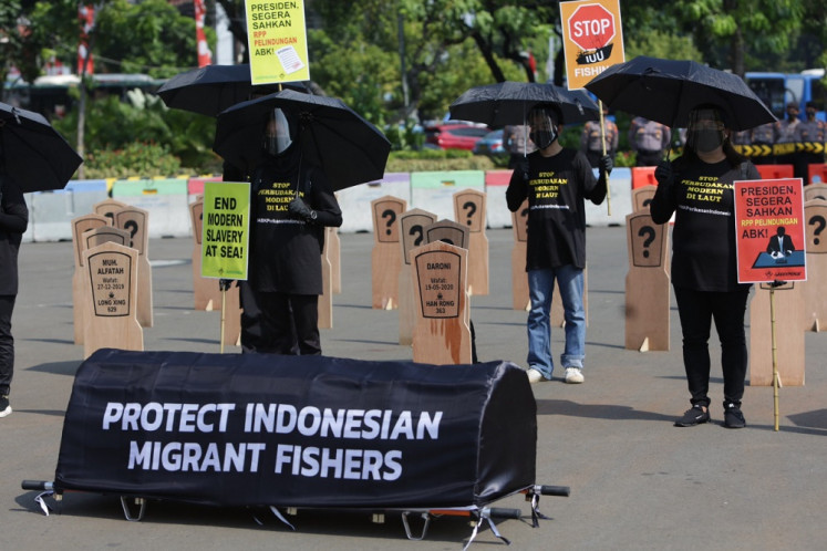 Show of solidarity: Activists from the Indonesian Migrant Workers Union (SBMI) and Greenpeace Indonesia stage a rally outside the State Palace in Jakarta on Aug. 17 to demand the enactment of a government regulation that will protect Indonesian fishers.