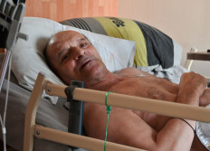 In this file photo taken on August 12, 2020 Alain Cocq, suffering from an orphan desease of the blood, rests on his medical bed in his flat in Dijon, northeastern France. 