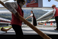 Alphorn blowers arrive on stage on September 4, 2020, in Camorino, southern Switzerland during the inauguration of the Ceneri Base railway tunnel, a two single-track 15,4 km long tunnel final part of the New Railway Link through the Alps (NRLA) construction project by Swiss authorities for faster rail links across the Alps aiming to mainly reduce transalpine truck traffic. 