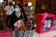 People wearing protective face masks shop at the French luxury foods group Fauchon’s flagship shop on the Place de La Madeleine in Paris, France, on September 4, 2020. 