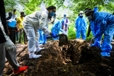 Christian volunteer Sagai Nair (L) and volunteers from a Muslim group dig a grave for a Covid-19 Coronavirus victim during a funeral at a cemetery in Pune on September 7, 2020. - India overtook Brazil on September 7 as the country with the second highest number of confirmed coronavirus cases, even as key metro train lines re-opened as part of efforts to boost the South Asian nation's battered economy.