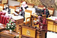 A staff member disinfects a microphone before a House of Representatives plenary session in Central Jakarta on September. 1. 2020. The session heard general views from party members on the draft 2021 state budget and endorsed a revision of the Constitutional Court Law. JP/Seto Wardhana