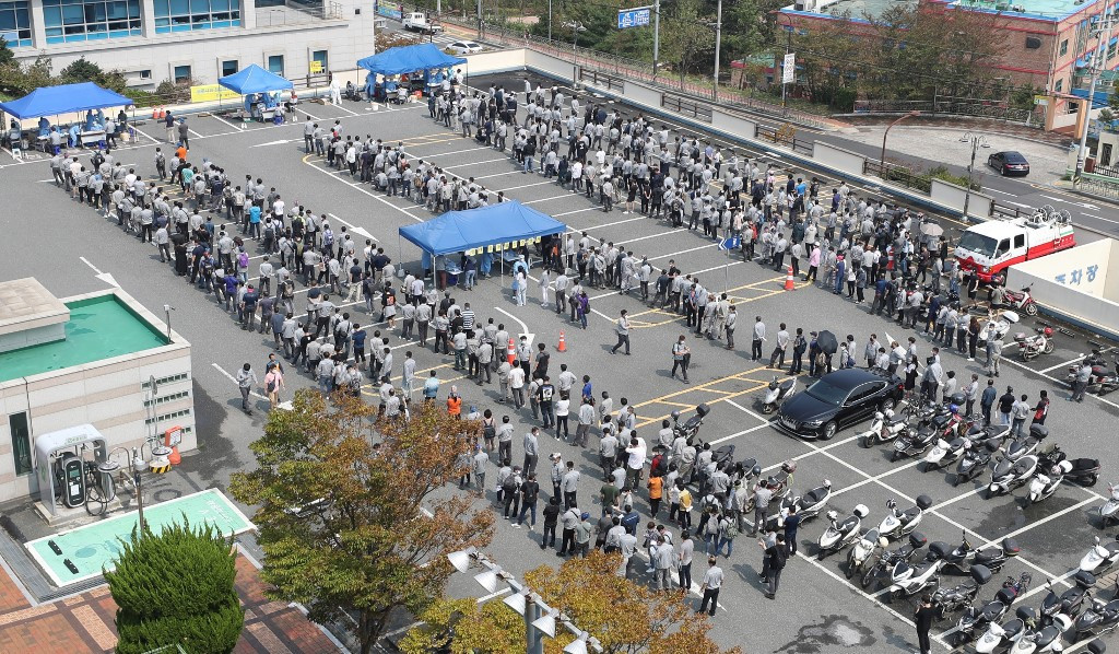 Hyundai Heavy Industries employees wait in lines to take tests for the COVID-19 coronavirus at a virus testing station in the southeastern port city of Ulsan on September 9, 2020, after seven people including company employees and their family members were confirmed as new coronavirus cases. - South Korea largely overcame an early coronavirus outbreak with extensive tracing and testing, but is now battling several outbreaks mostly linked to Protestant churches. 