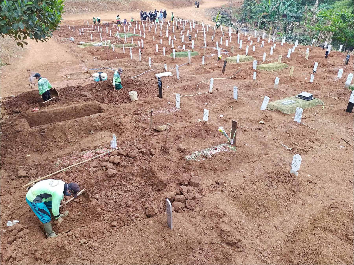 Gravediggers at Pondok Ranggon Cemetery in East Jakarta dig graves for COVID-19 victims on Wednesday. The rate of COVID-19 funerals in Pondok Ranggon is high with 700 to 720 funerals per month.