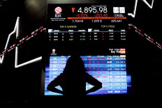 A visitor observes an electronic board showing movements on the Jakarta Composite Index at the Indonesia Stock
Exchange in Jakarta.
