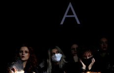 A person in the audience wears a mask as she attends the Dolce & Gabbana Autumn/Winter 2020 collection show during Milan Fashion Week in Milan, Italy, on February 23, 2020. 