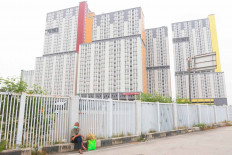 A COVID-19 patient waits for an ambulance that will take him to a COVID-19 referral hospital in Kemayoran, Central Jakarta.