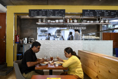In this photograph taken on August 26, 2020, customers eat sitting at a table at CoCo Ichibanya Japanese curry chain restaurant in Gurgaon on the outskirts of New Delhi. 