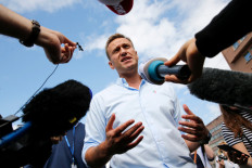This file photo taken on July 20, 2019 in Moscow shows Russian opposition leader Alexei Navalny speaking with journalists during a rally to support opposition and independent candidates after authorities refused to register them for September 2019 elections to the Moscow City Duma. Russian opposition leader Alexei Navalny's condition is improving and he is able to get out of bed for brief periods, the German hospital treating him said Monday. 

