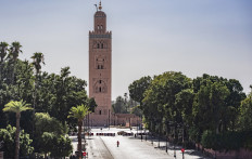 A few people walk by next to the Kutubiyya mosque's minaret tower at the Jemaa el-Fna square in the Moroccan city of Marrakesh on September 8, 2020, currently empty of its usual crowds due to the COVID-19 pandemic. 