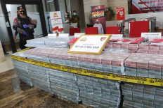 Police officers guard stacks of cash totaling Rp 56.8 billion that were seized as  evidence in a fraud case involving the purchase of ventilators at the National Police Headquarters in Jakarta, Sept. 7, 2020. Bareskrim head Comr. Gen. Listyo Sigit Prabowo said a syndicate had stolen money transferred under a contract of sale between two foreign healthcare technology firms: Althea Group from Italy and Shenzhen Mindray Bio-Medical Electronics from China. JP/Dhoni Setiawan