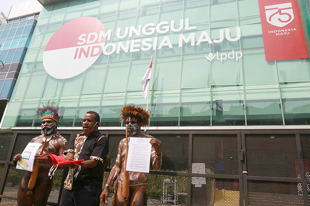 Solidarity: Wearing traditional Papuan dress, members of the Ebamukai Solidarity Team for Indonesian human rights lawyer Veronica Koman show documents in front of the Endowment Fund for Education (LPDP) office in Jakarta, on Sept. 9, 2020, as they sought to reimburse scholarship money totaling Rp 773.8
million (US$51,900). The lawyer was asked to return the funding, which she received from the LPDP, as it said that she had failed to return home to Indonesia after her studies. Security officers prevented them from entering the office, saying that the office was closed because of the large-scale social restrictions.