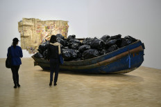 Visitors look at an installation called 'hope' by Algerian artist Adel Abdessemed as part of the exhibition 'La Terra Inquieta' (The Restless Earth) on migrants odissey organized by the Trussardi foundation during La Triennale di Milano on April 27, 2017.
